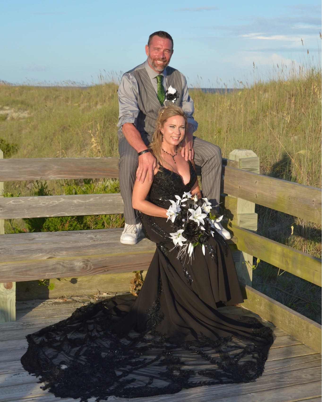 Couple on beach boardwalk in wedding attire